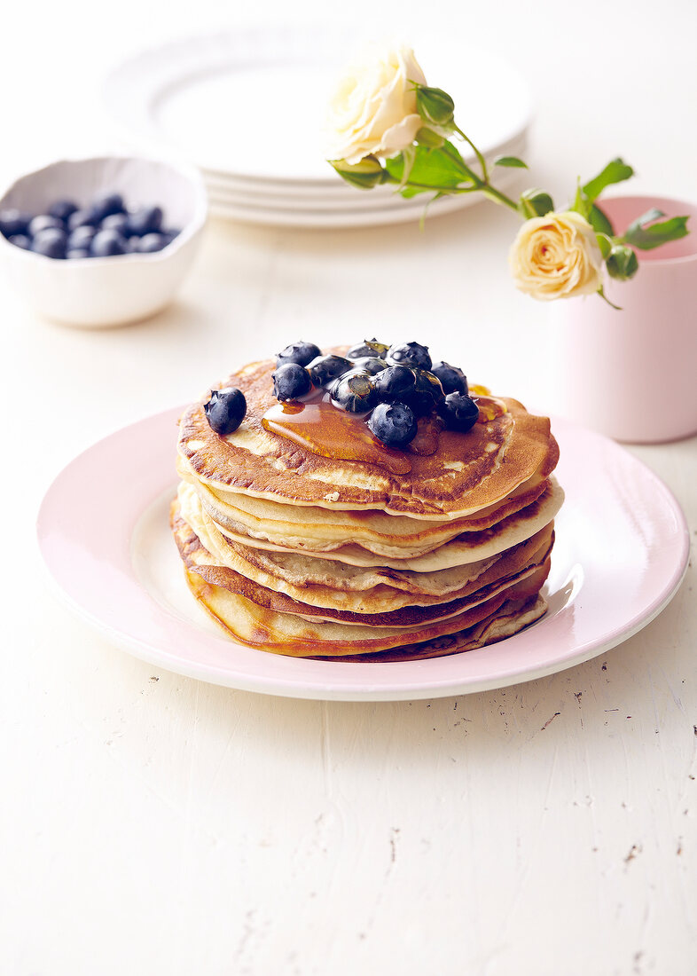 Stack of pancakes with blueberries and honey
