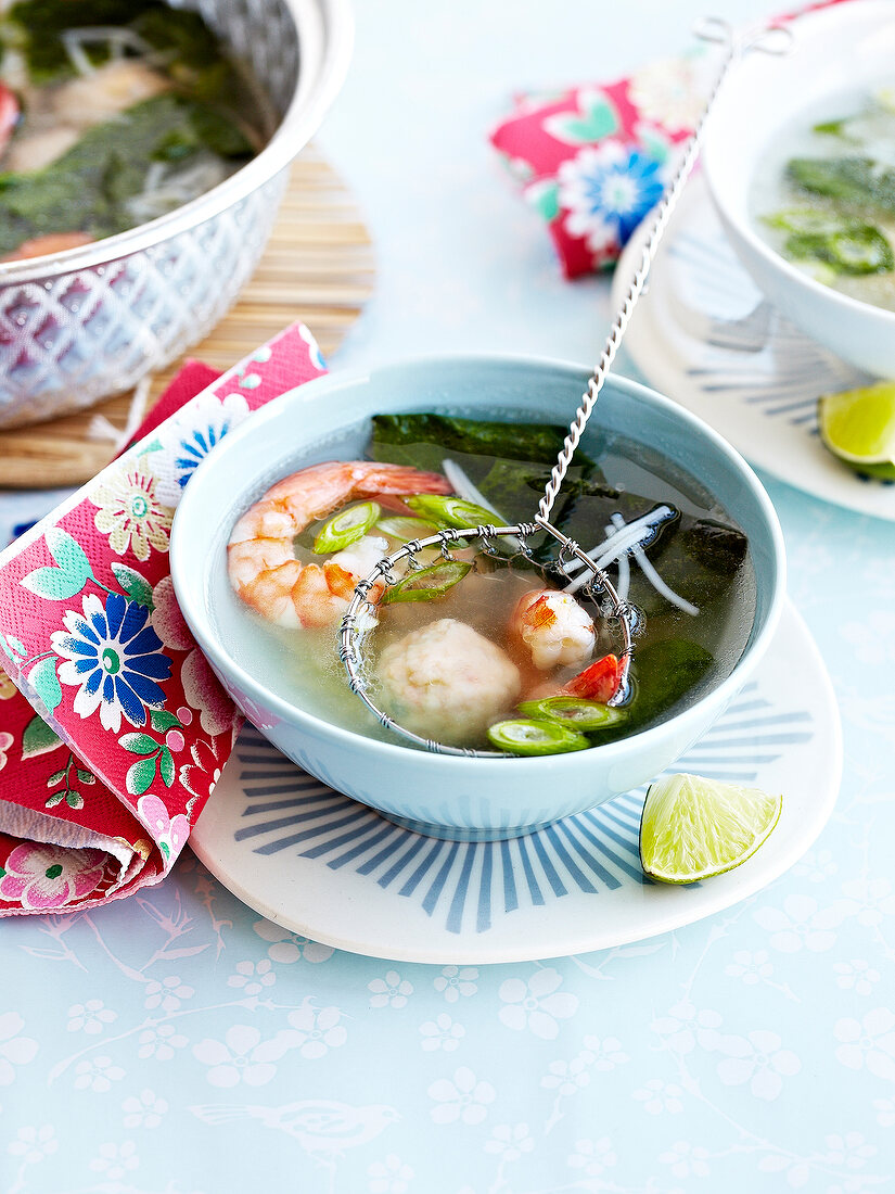 Klare, asiatische Suppe mit Garnelen, Fischbällchen und Algen