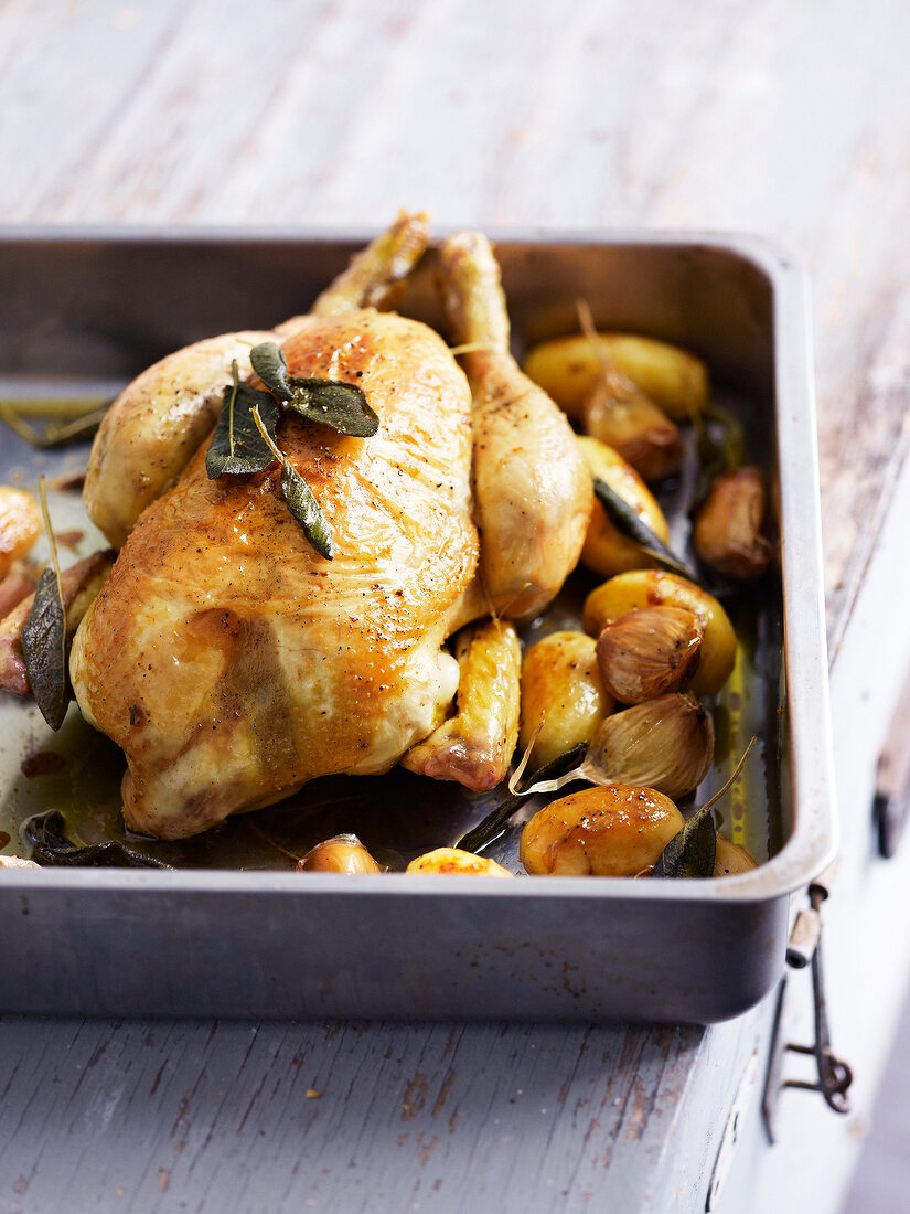 Roasted chicken with sage, roasted potatoes and garlic