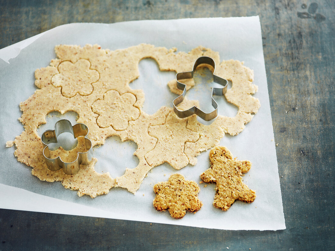 Cutting out shapes in the dough with a biscuit cutter for cookies