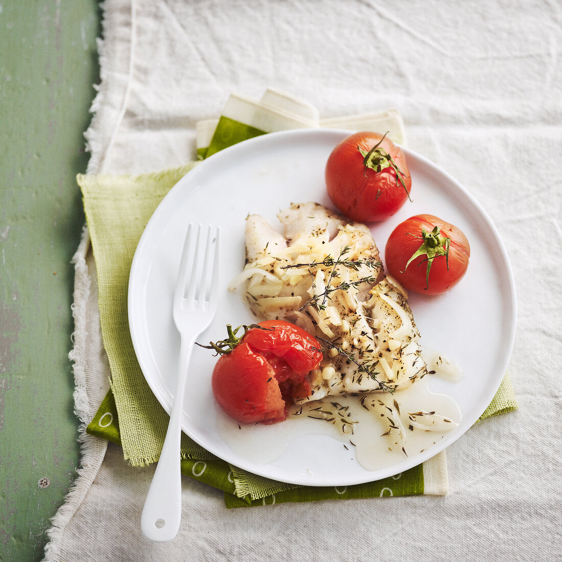 Steamed piece of cod with thyme, onions and cherry tomatoes