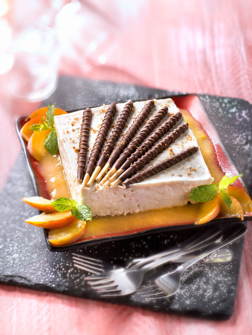 Käsekuchen mit Pfirsichpüree, Minze und Schokostäbchen