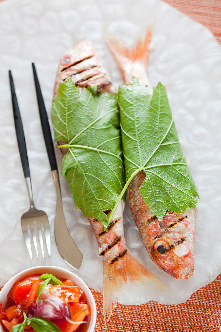 Grilled red mullets wrapped in vine leaves ,tomato salad