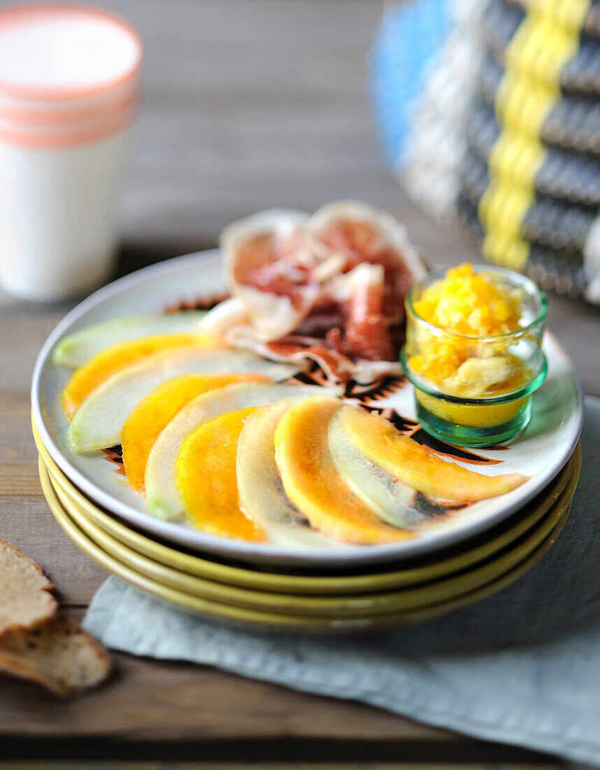 Two types of melon thinly sliced ,melon granita and raw ham