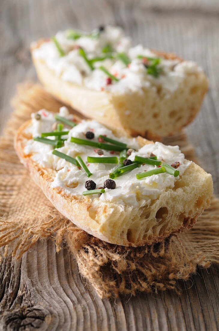 Fresh goat's cheese with pepper and chives spread on bread