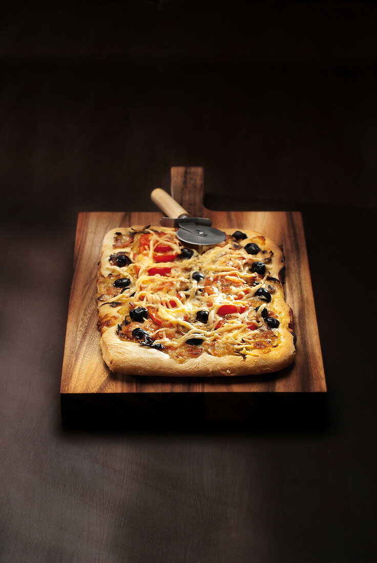 Pizza mit Tomaten, schwarzen Oliven und Käse