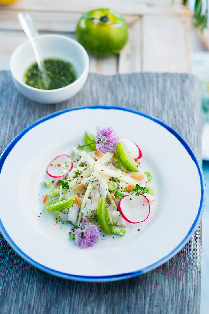 Kabeljautatar mit Radieschen, grünen Äpfeln und Tomaten, Essblüten und Sauce Vierge