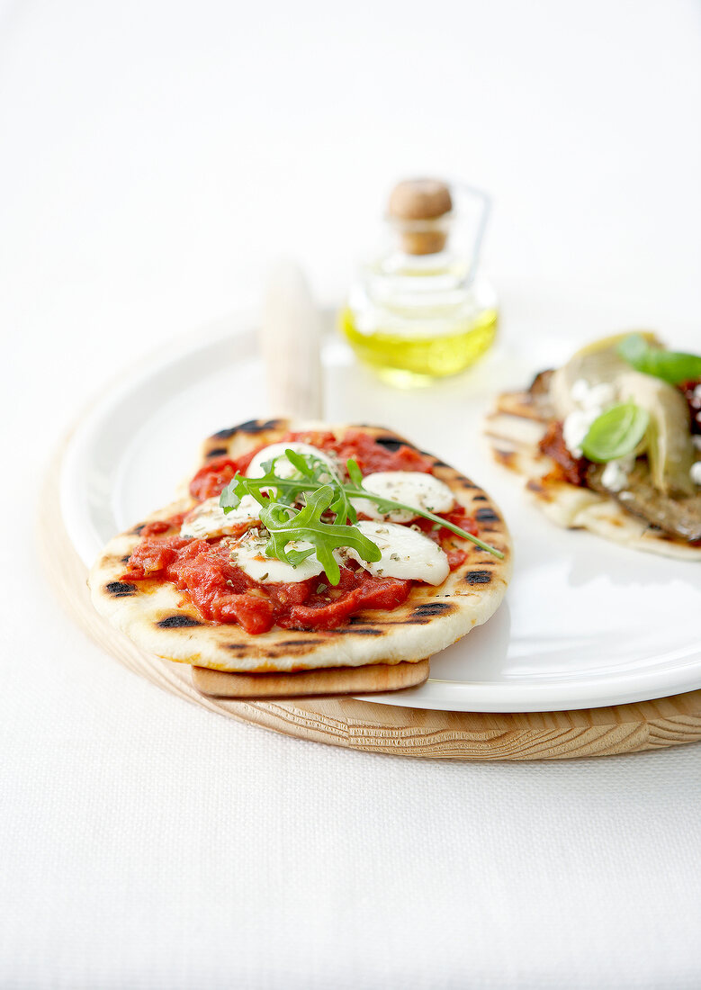 Pitabrot mit Tomaten und Mozzarella und Pita mit Artischocken, Anchovis und Basilikum im Pizza-Stil