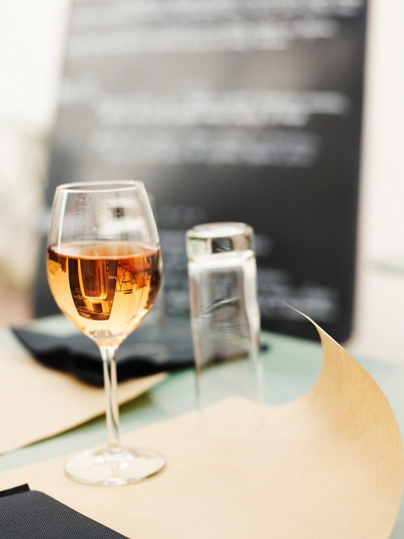 Ein Glas Roséwein auf Tisch in einem Restaurant