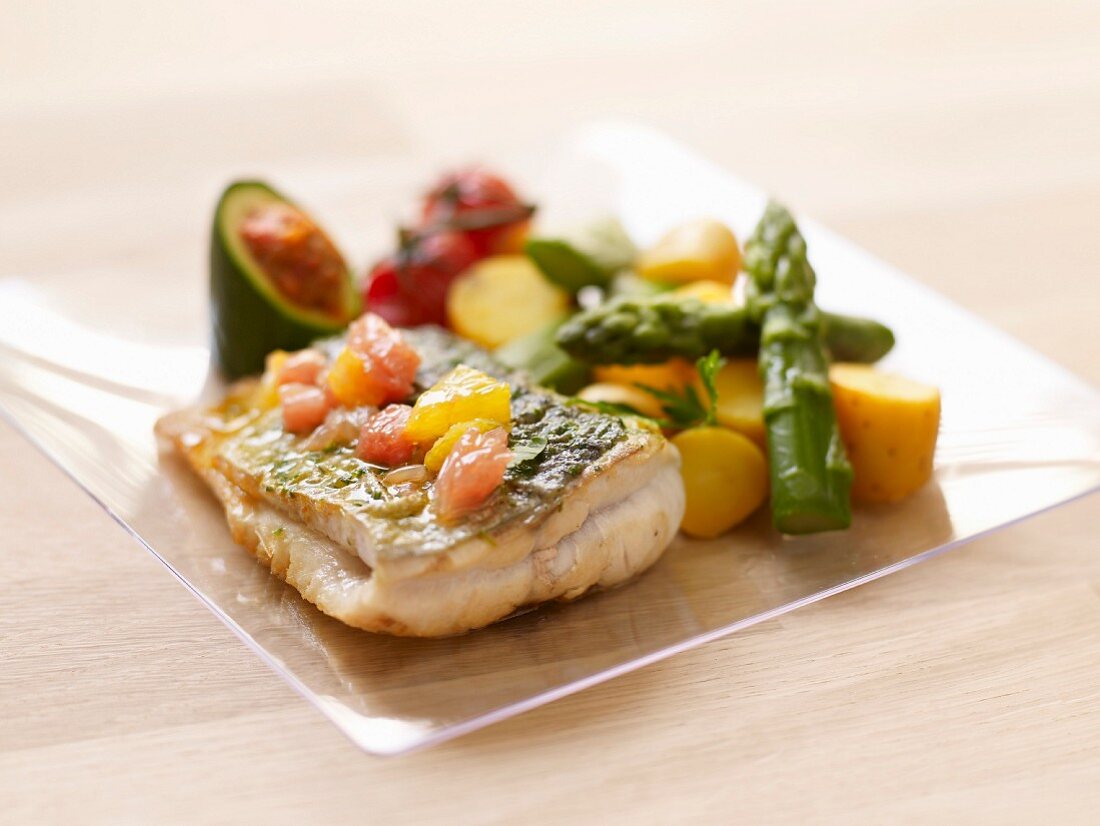 Piece of sea bass with citrus fruit, asparagus-potato salad and stuffed zucchini