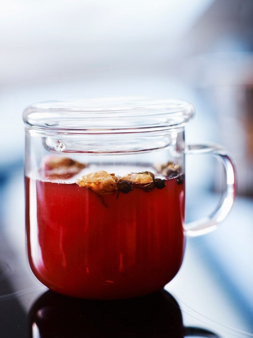 Roter Rooibostee mit braunem Rum, Rosenknospen, Orangenblüten und weißem Kardamom