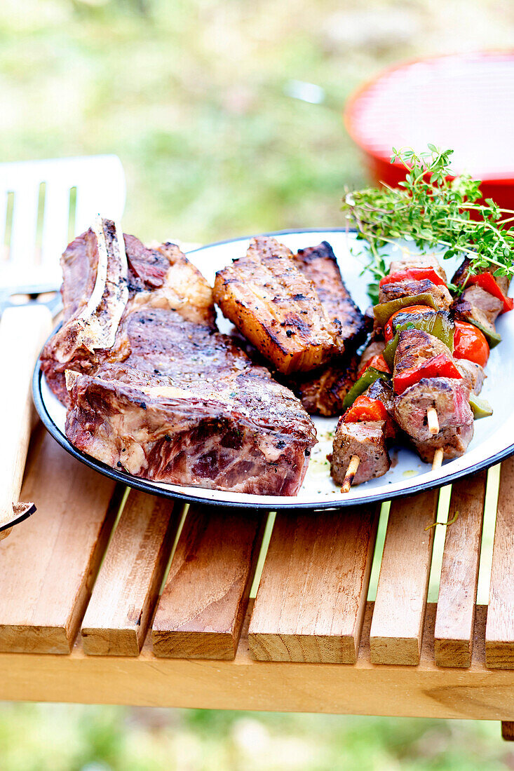 Grillteller mit Fleisch auf Tisch im Freien