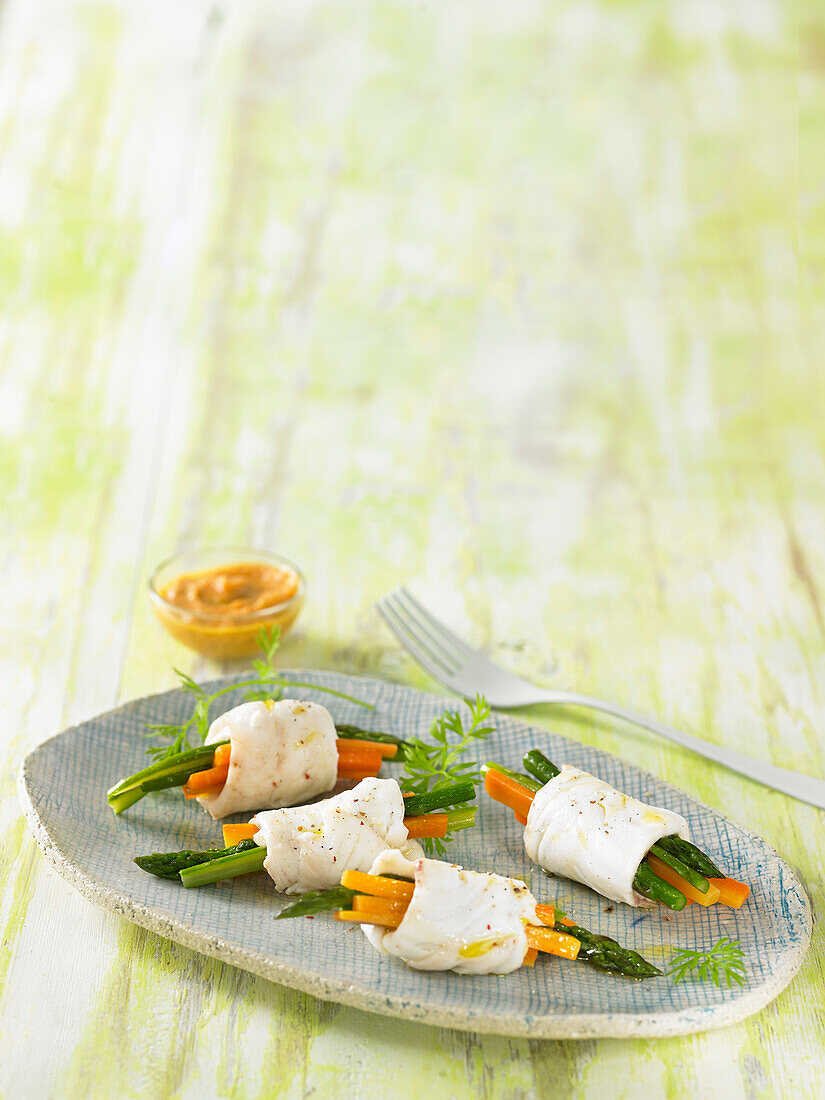 Sea bream rolls with green asparagus and carrots