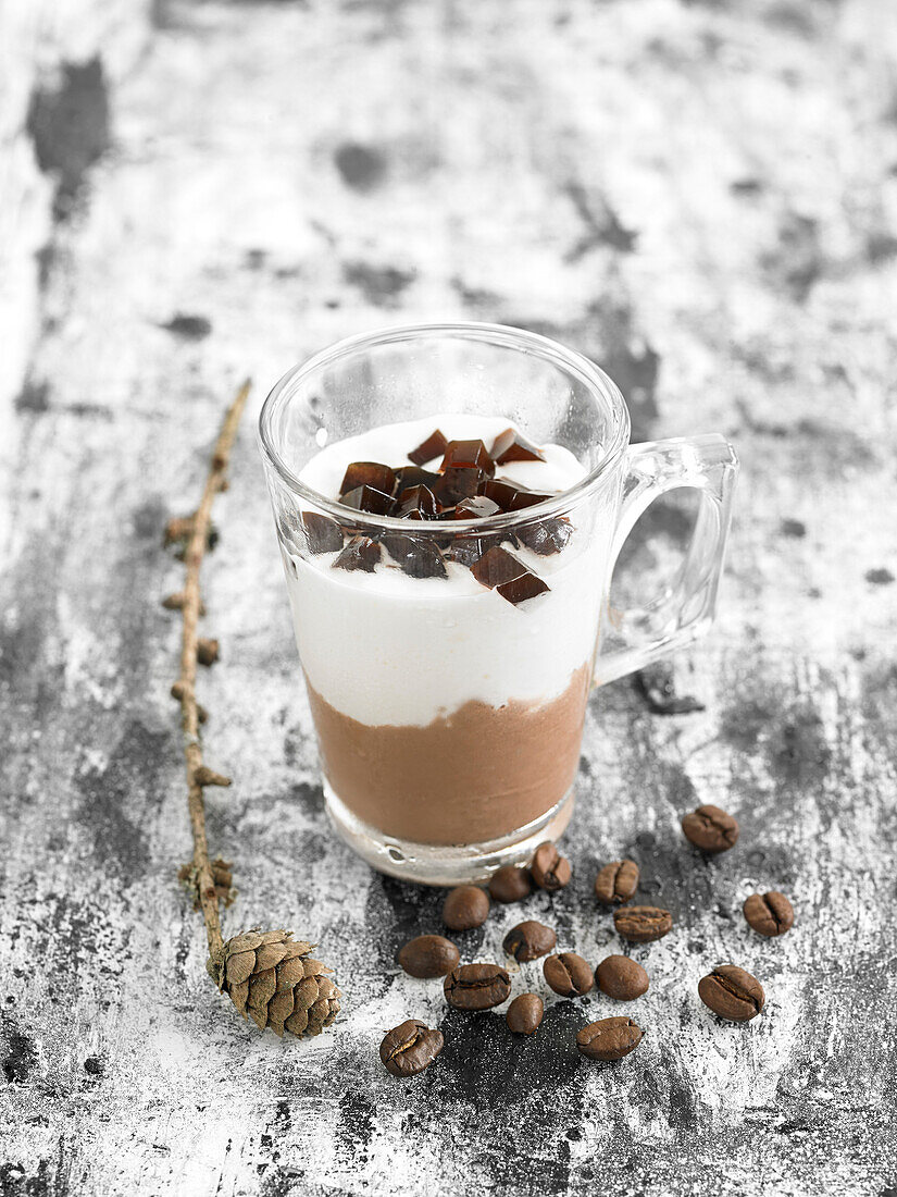 Schokoladenmousse mit Schlagsahne und Kaffeegelatinestückchen, im Glas serviert