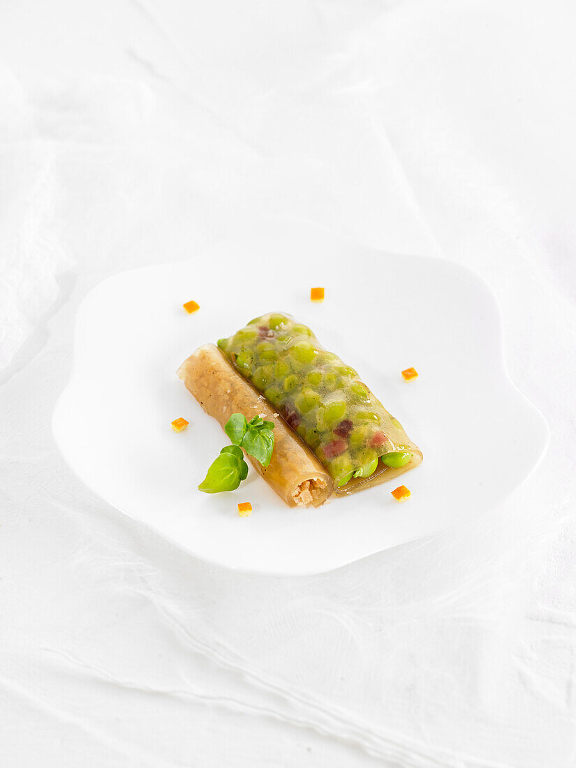 Poultry broth gelatin sheets stuffed with peas and Iberian ham