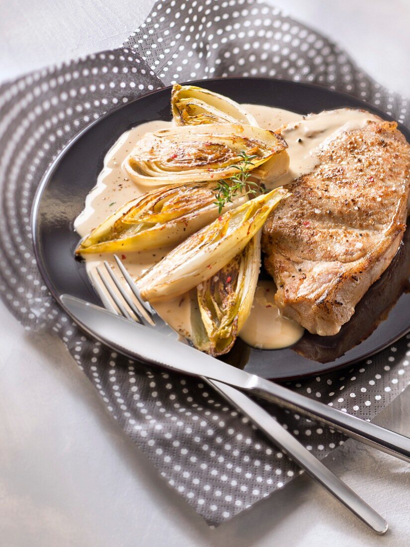 Veal chop with braised chicory and creamy cider sauce
