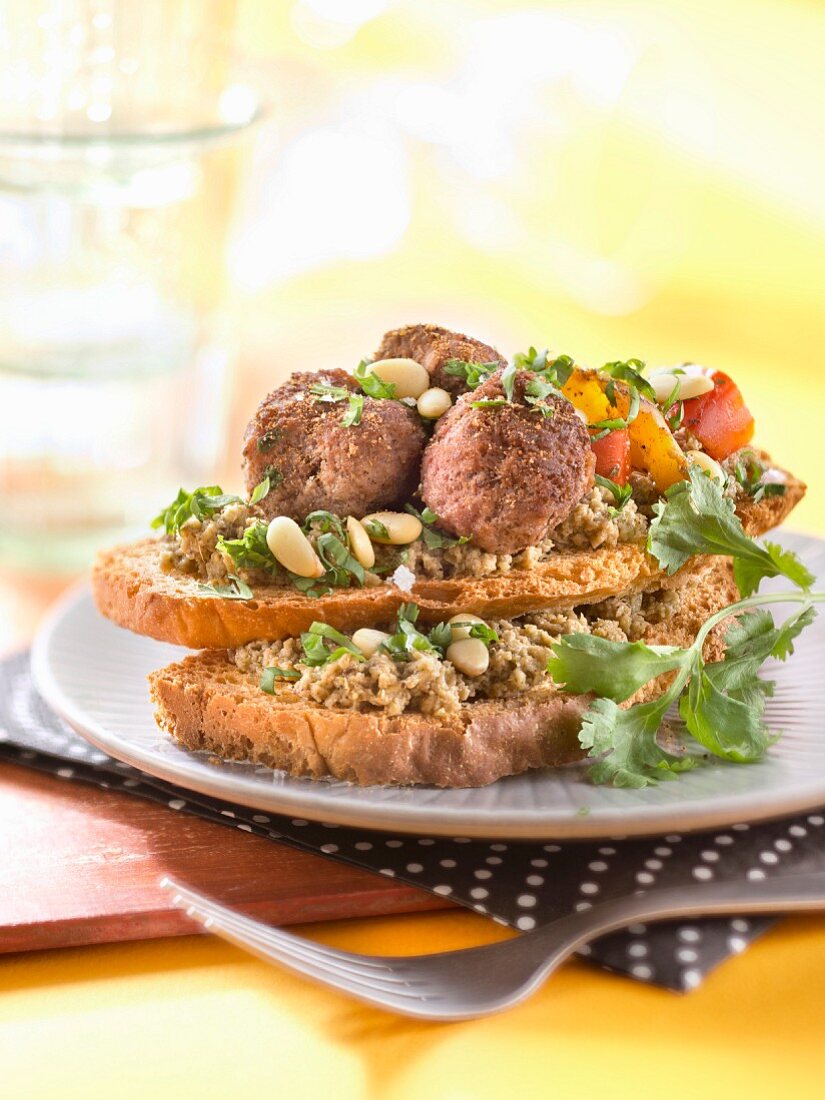 Pesto, Hackfleischbällchen und eingelegte Paprika auf Röstbrot