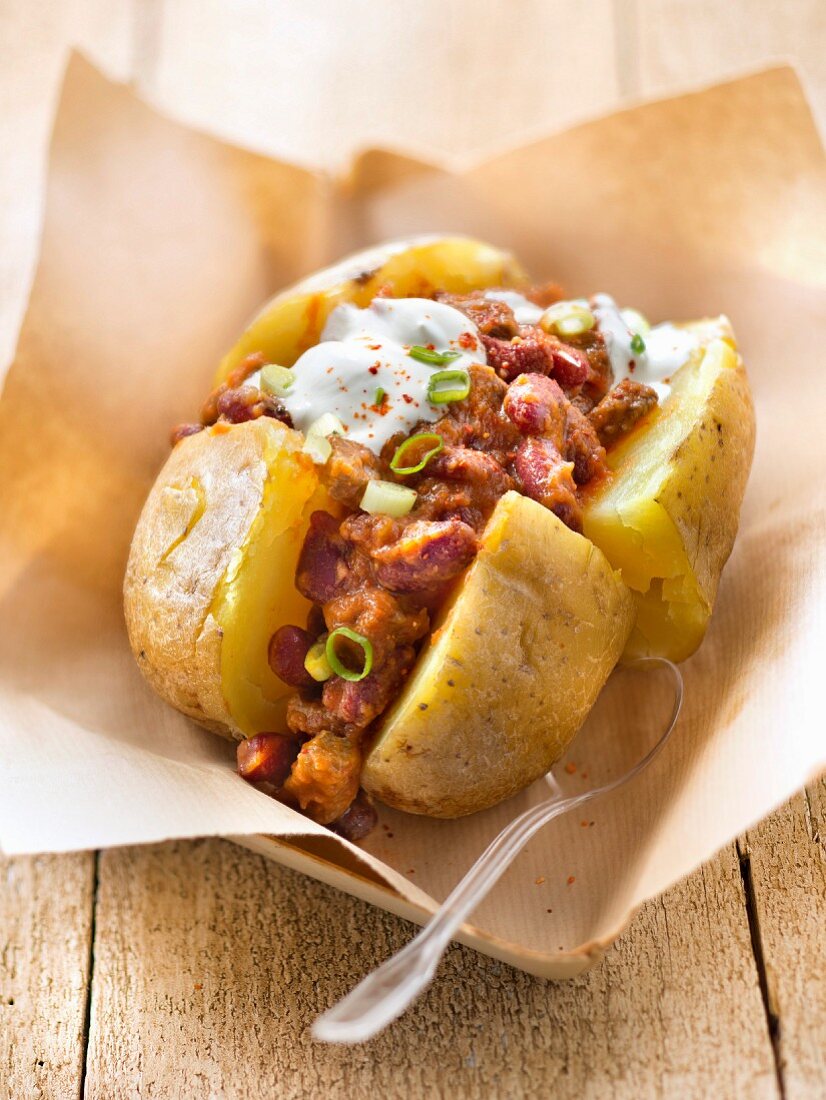 Baked potato garnished with chili con carne