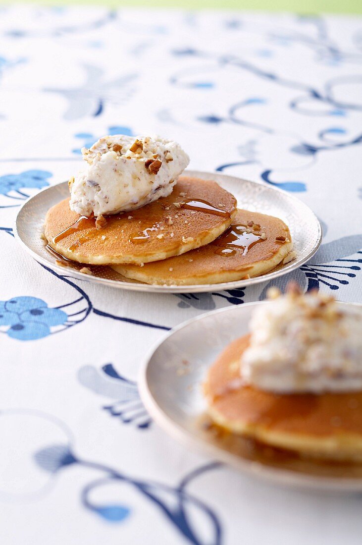 Pancakes garnished with white chocolate mousse,pecans and maple syrup