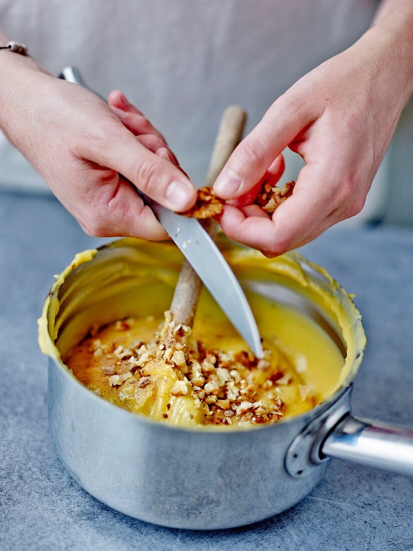Adding the crushed walnuts in to the choux pastry preparation