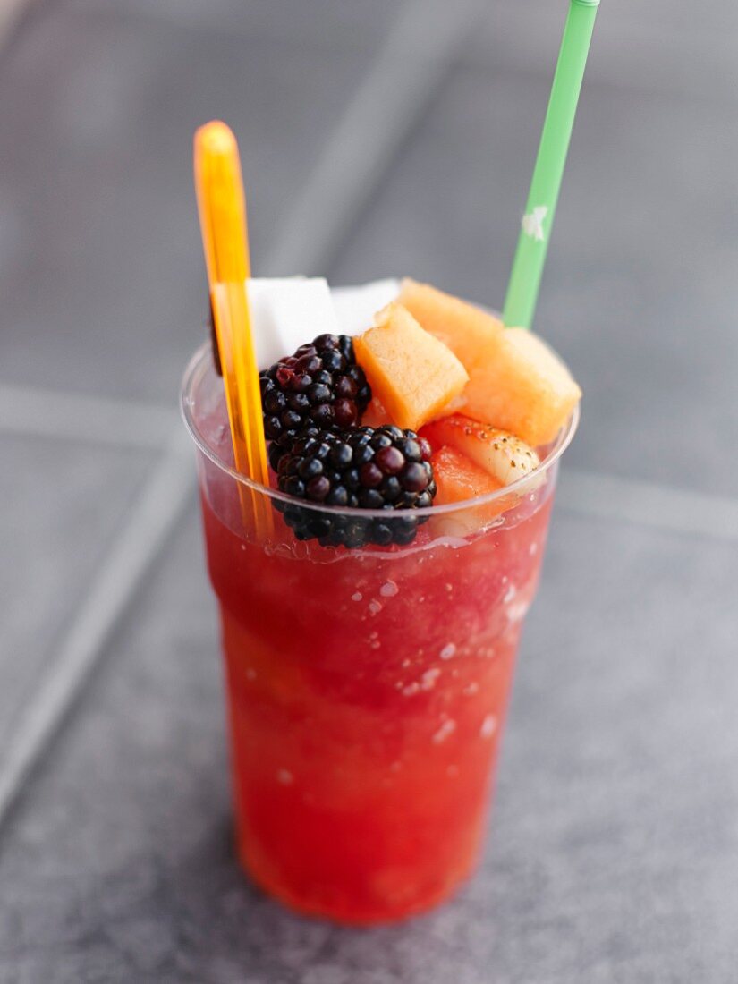 Glass of watermelon-strawberry granita topped with fresh fruit
