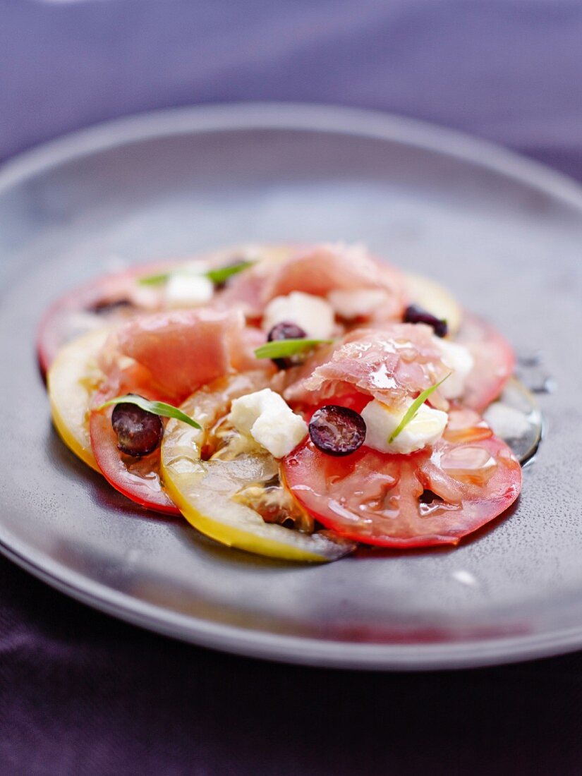 Red and yellow tomato carpaccio with raw tuna,cranberries and feta