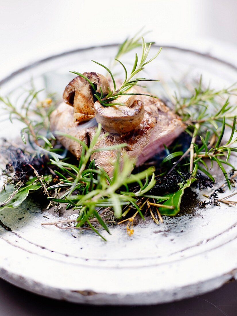 Veal smoked on a scrubland fire with mushrooms