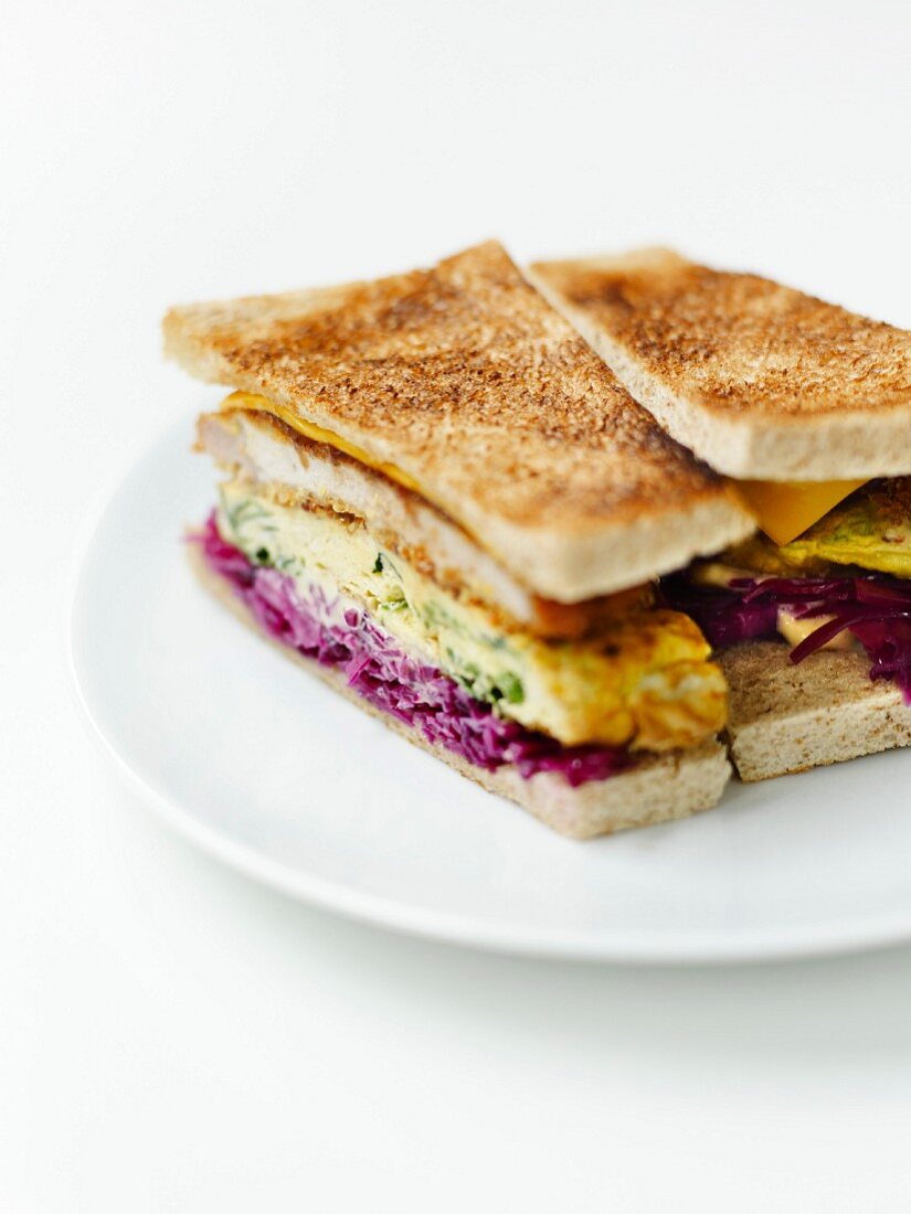 Sandwich mit Schweinefleisch-Tonkatsu, Rotkohljulienne, Gemüseomelett und Worcestershiresauce