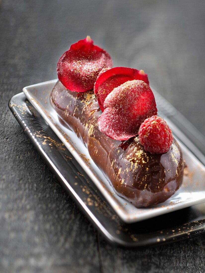 All chocolate Eclair with raspberries and rose petals