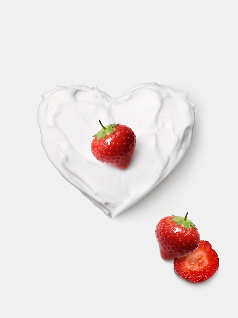 Whipped cream heart topped with a strawberry