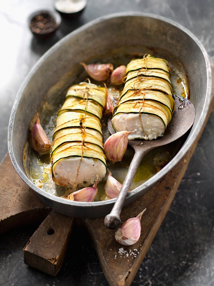 Roasted hake wrapped in zucchini strips with garlic