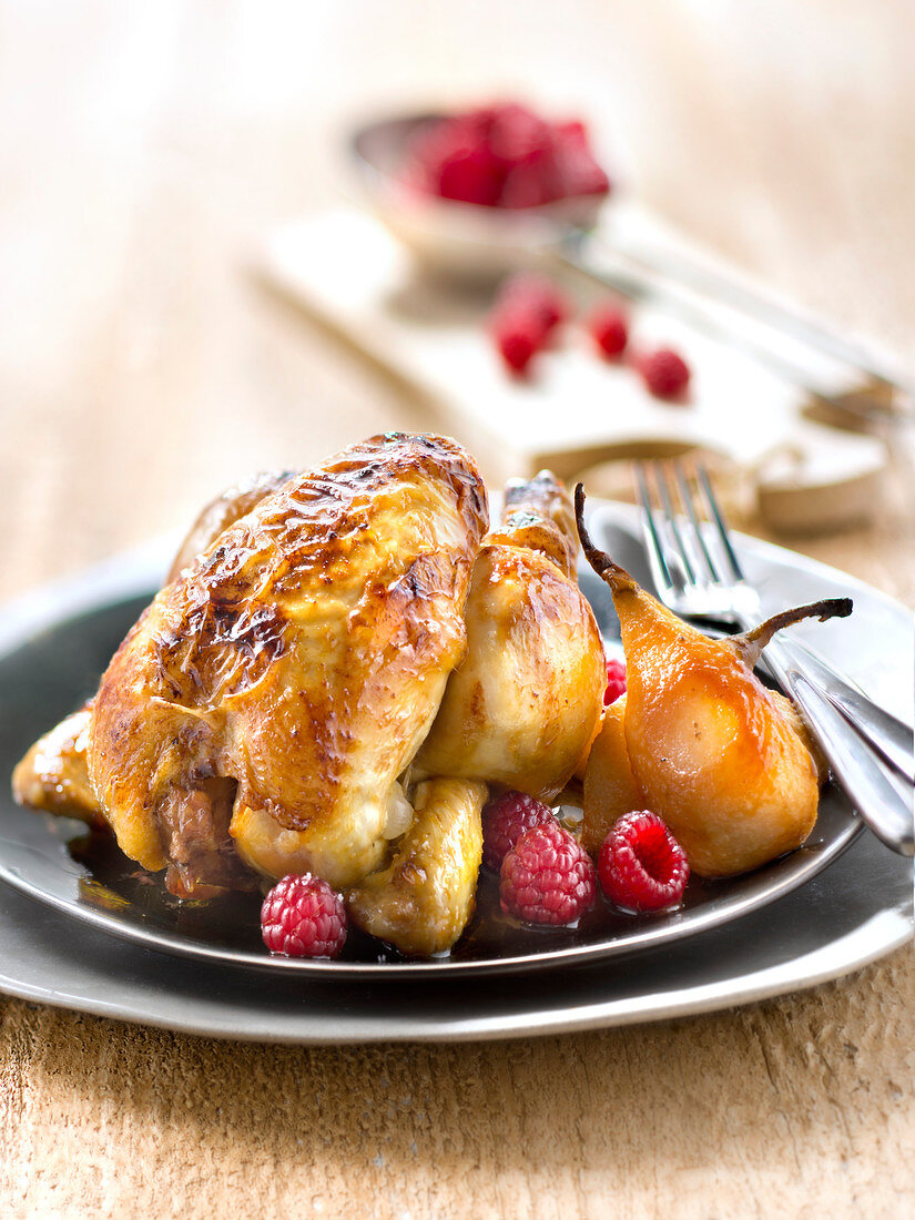 Roasted young cockerel with pears and raspberries
