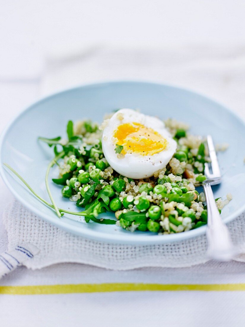 Salat mit Erbsen, Quinoa, Pinienkernen und wachsweichem Ei