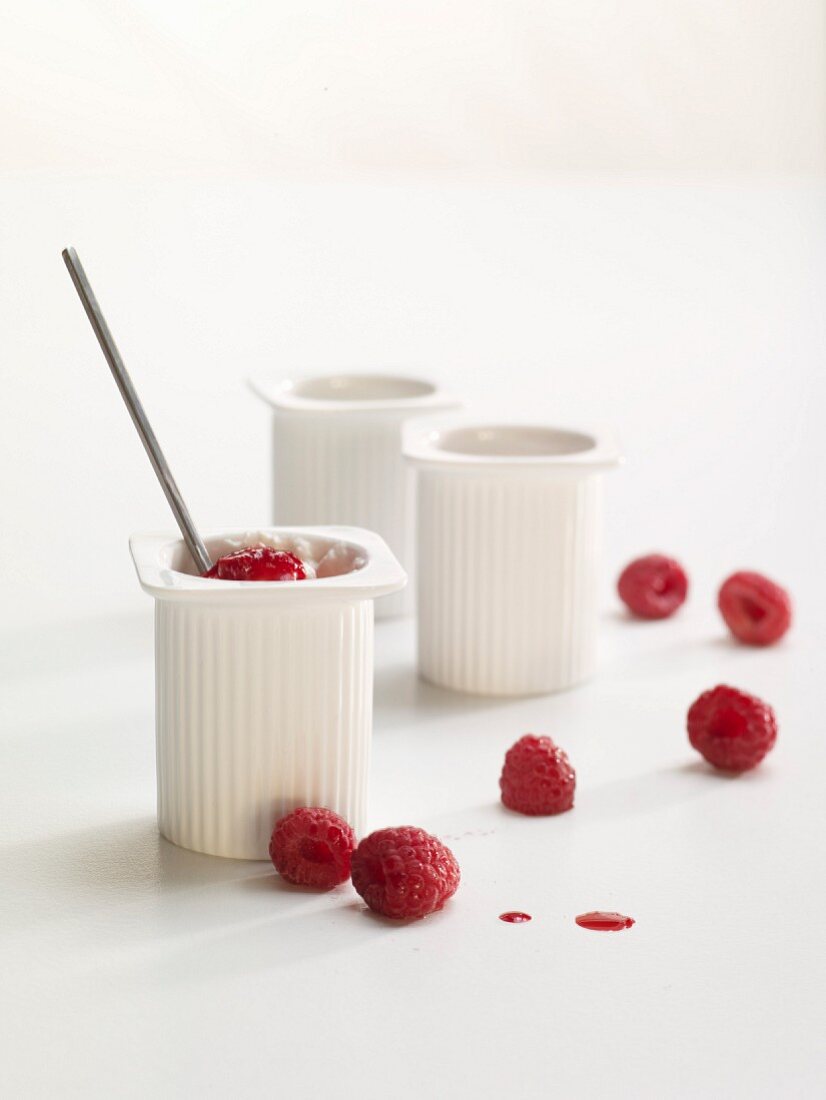 Drei Petit-Suisse-Becher mit Himbeeren