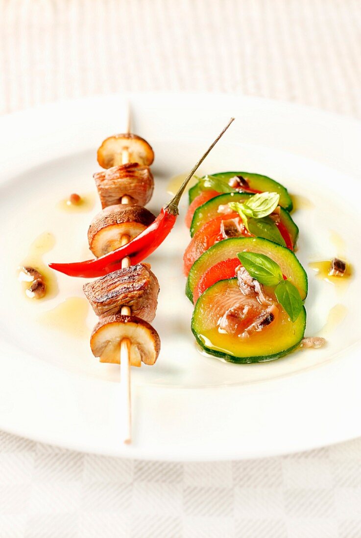 Beff,mushroom and chili pepper brochette,sliced cougette,tomato,anchovy and basil