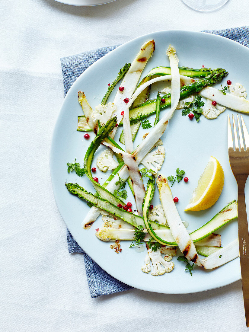 Grilled asparagus and cauliflower strips with lemon and pink pepper