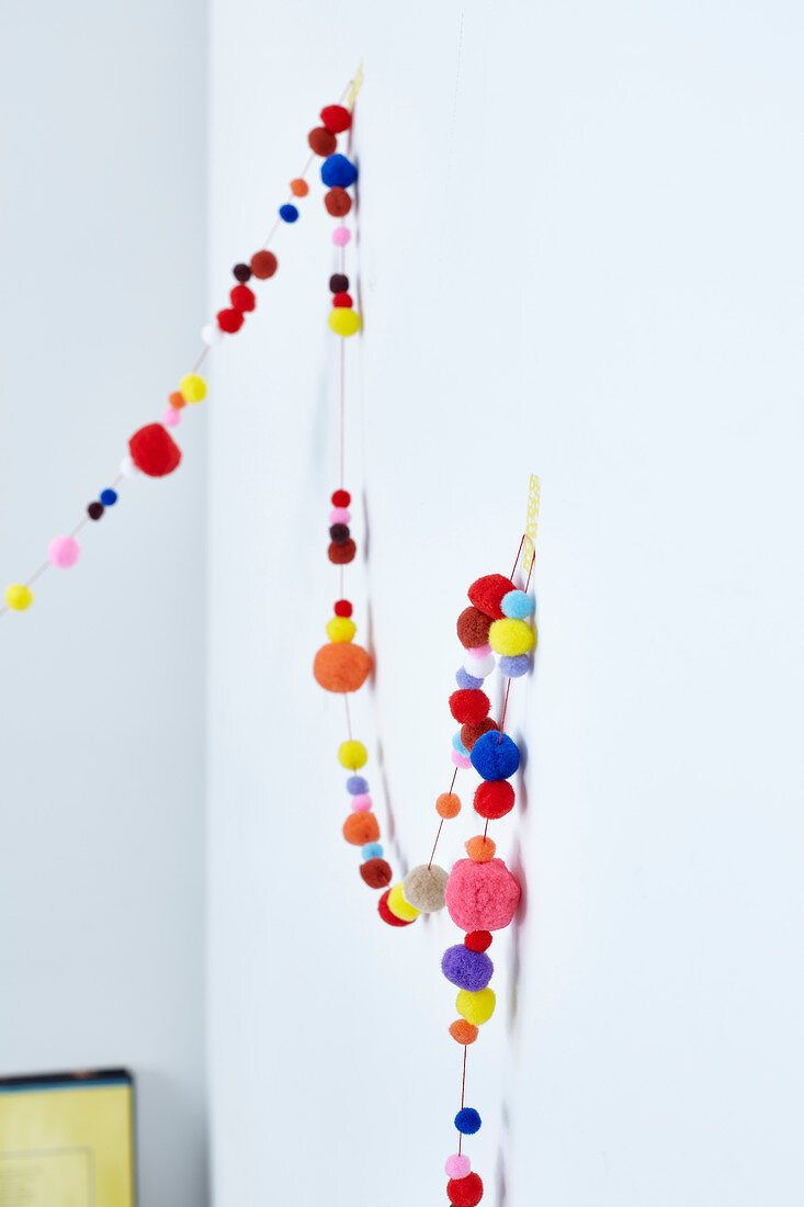 Colourful garland made of wool pom-poms