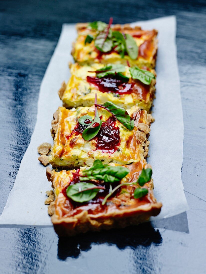 Herzhafte Quiche mit Zucchini, rote-Zwiebel-Chutney und Blättern von Roter Bete