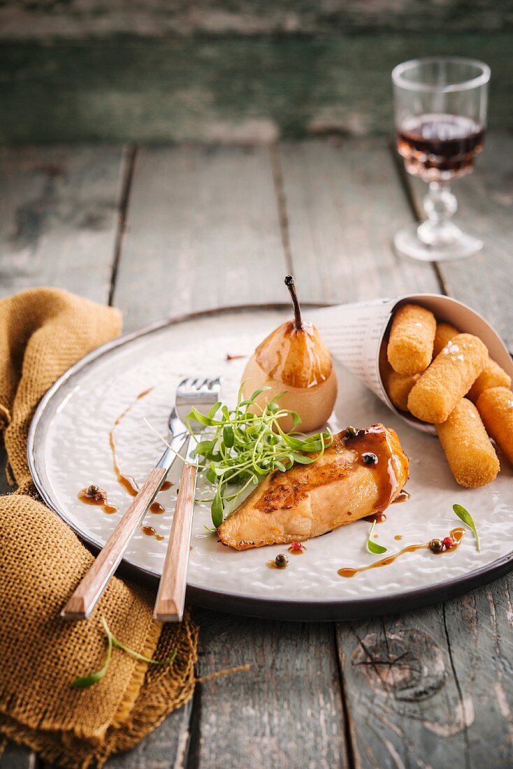 Hähnchenbrust mit Portweinsauce, pochierte Birne und Kartoffelkroketten