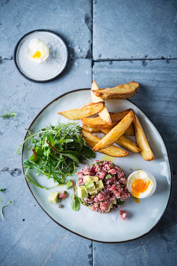 Rindertatar mit Avocado, wachsweichem Ei und Pommes Frites