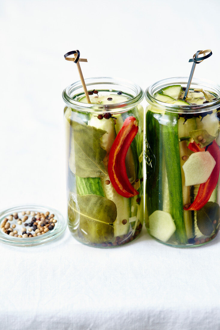 Pickled cucumbers with chili peppers and spices in preserving jars