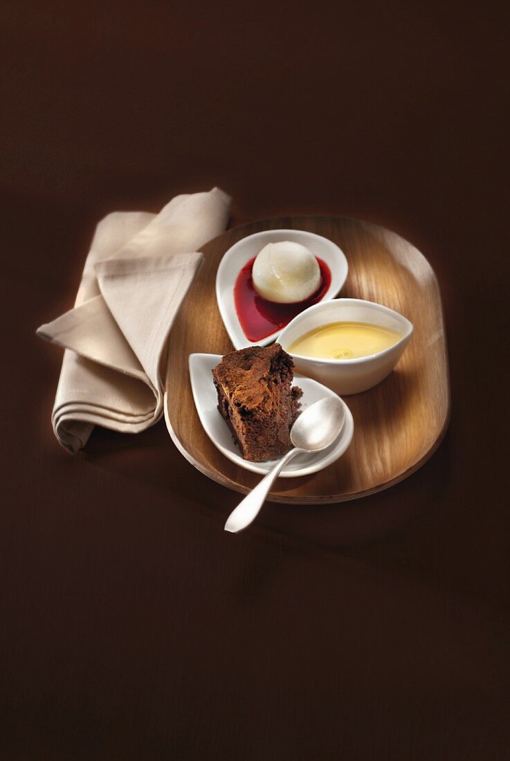 Cinnamon-flavored brownie with a scoop of ice cream, custard and summer fruit coulis