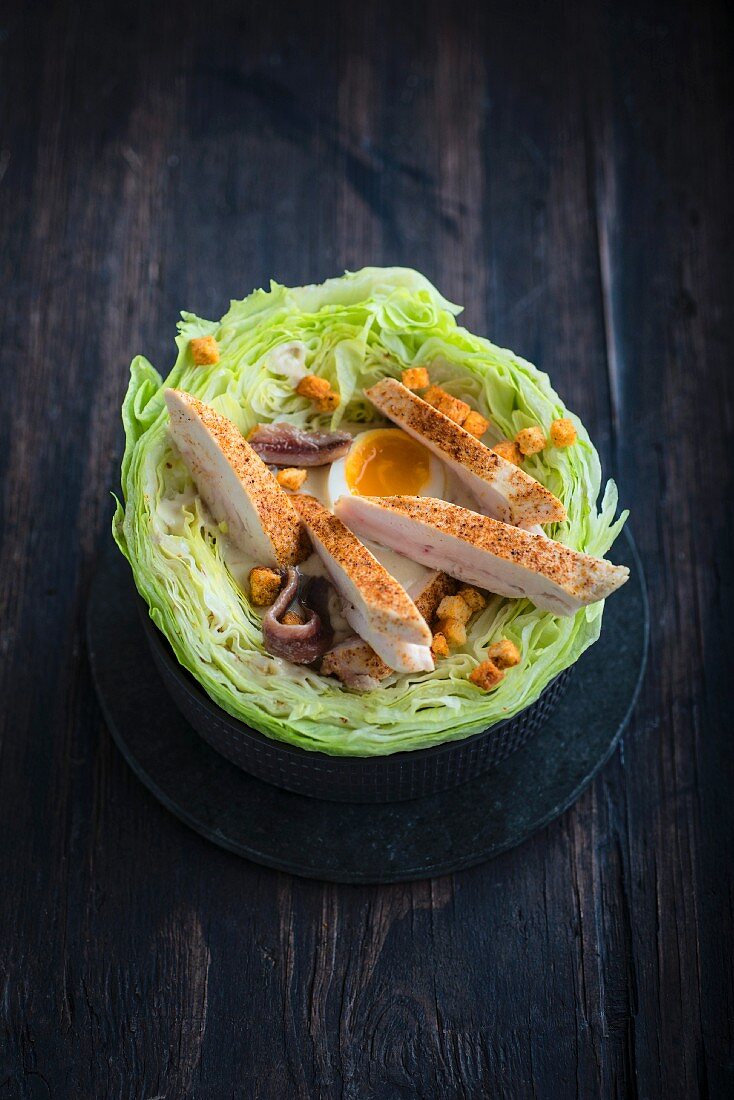 Marinated chicken breast,soft-boiled egg and anchovy salad served in a cabbage