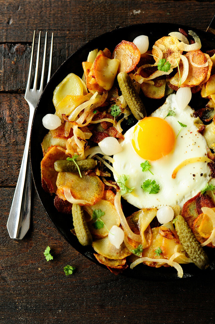 Potatoes with pickles and a fried egg