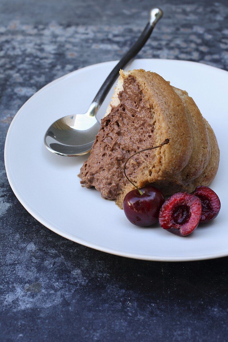 A slice of Charlotte with chocolate mousse and cherries