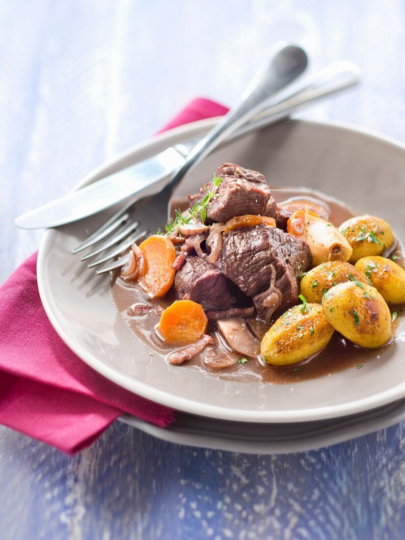 Boeuf Bourgignon (Rindfleisch in Rotweinsauce, Frankreich) mit goldbraun gebratenen Knoblauch-Kartoffeln