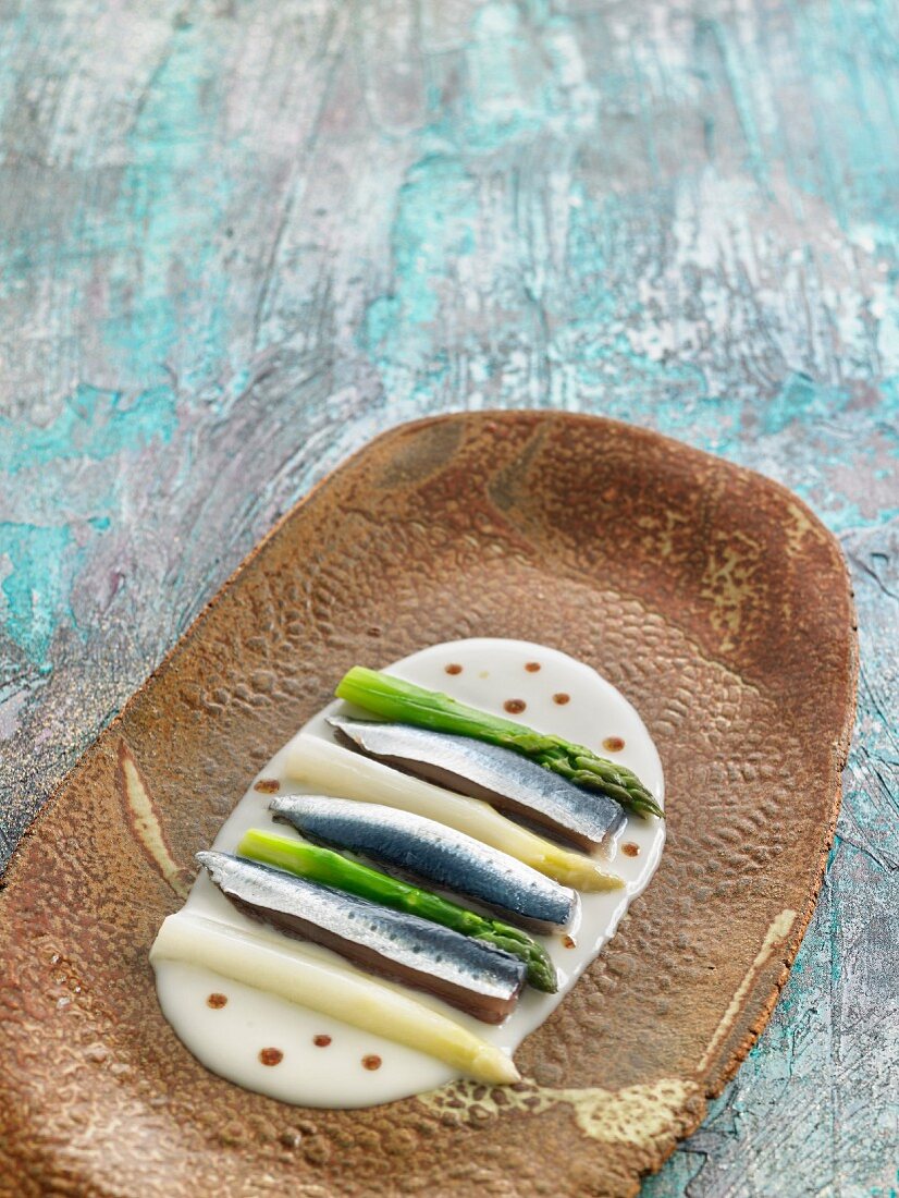 Raw sardines with green and white asparagus on horseradish sauce