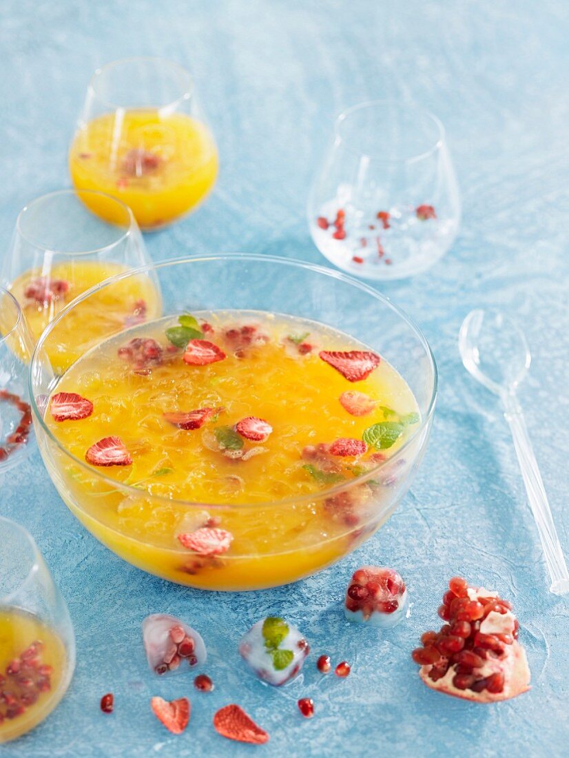 Orange juice with strawberries and pomegranate seeds