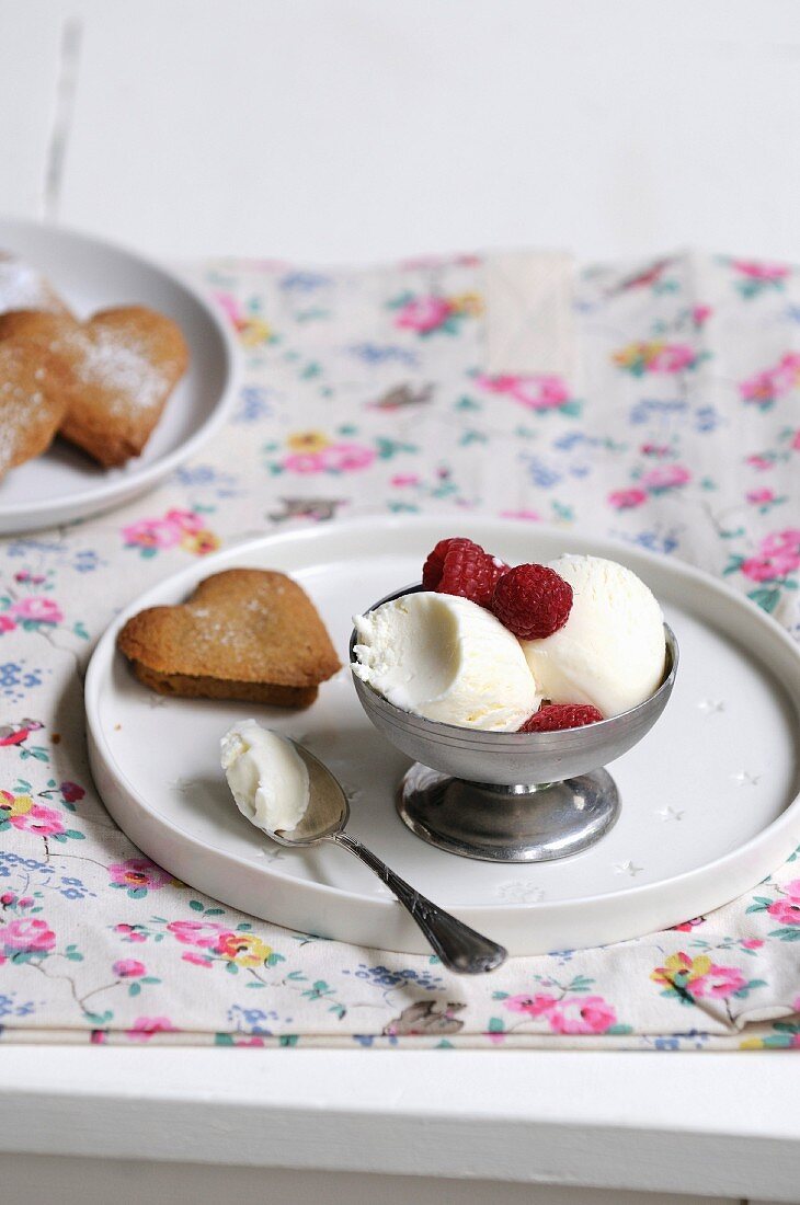 Eisbecher mit Litschisorbet und Himbeeren, herzförmiges Schokogebäck