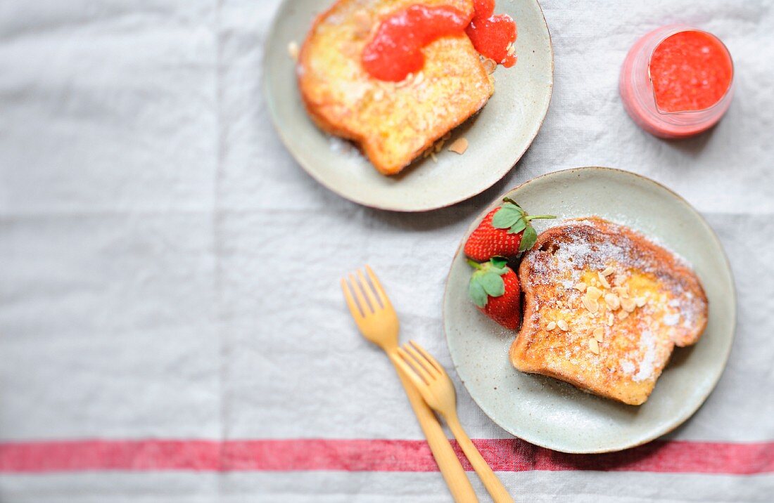 Brioche french toast with thinly sliced almonds and strawberry coulis